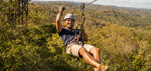 Traveler zip-lining through the tropical dry forest in Guanacaste